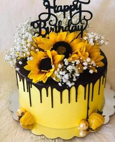 a yellow and black birthday cake with sunflowers