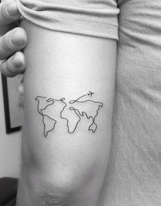 a small world map tattoo on the arm