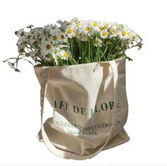 a bag filled with white daisies on top of a table