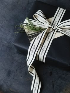 a wrapped black gift box with a ribbon tied around it