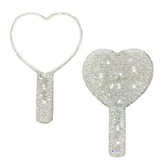 two silver heart shaped brooches with chains attached to them, one in the shape of a key