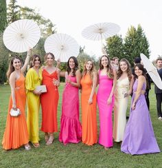 a group of women standing next to each other holding white parasols in their hands