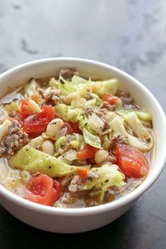 a close up of a bowl of food with broccoli, tomatoes and beans