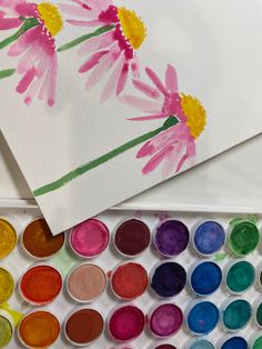 the watercolors are being used to paint flowers