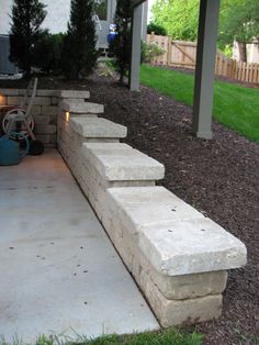 a stone bench sitting in the middle of a yard