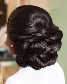 the back of a woman's head with dark brown hair in a low bun