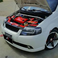 a white car with its hood open showing the engine