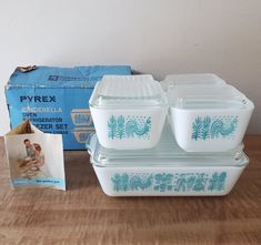 a set of three pyrrex glass containers with blue designs on the lids