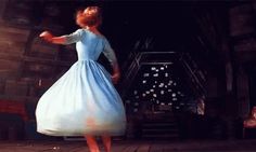 a woman in a blue dress is dancing