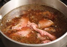 meat is cooking in a pot on the stove