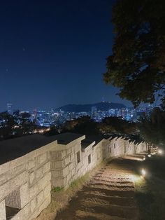 the city lights shine brightly in the night sky over an urban area with stone walls and steps