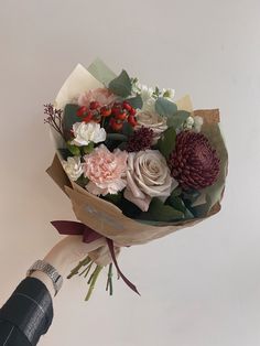 a person holding a bouquet of flowers in their hand