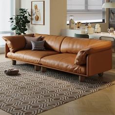 a brown leather couch sitting on top of a wooden floor