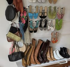 there are many shoes and purses hanging on the wall