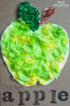 an apple made out of tissue paper on top of a cardboard box with the words tissue paper apples