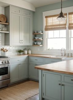 a kitchen with gray cabinets and wooden counter tops