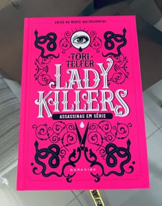 a person holding up a pink book with black lettering that reads, tortel lady killers assinas mi serie