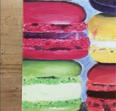 a painting of colorful donuts on a wooden surface