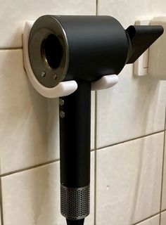 a black and white hair dryer on the wall