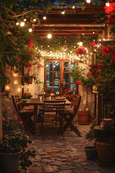 an outdoor dining area with potted plants and lights