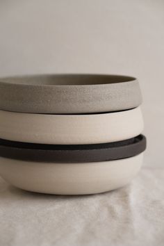 three white and black bowls stacked on top of each other