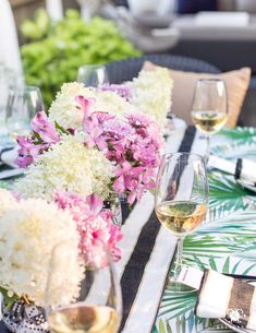 the table is set with flowers and wine glasses