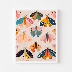 a card with colorful moths on it, in front of a white wall and floor