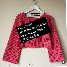 a pink knitted sweater hanging on a hanger