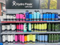 the hydro flasks are lined up on the shelf in the store for sale