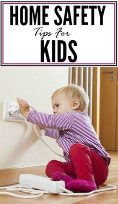 a toddler sitting on the floor playing with a power strip