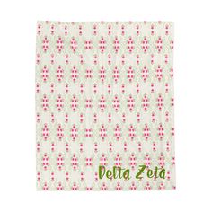 a white towel with pink flowers and the word delta zota on it in green lettering