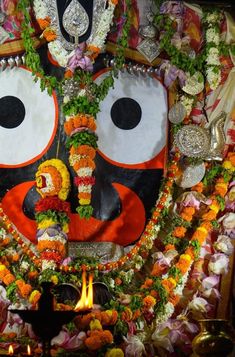 a decorated face with flowers and garlands around it