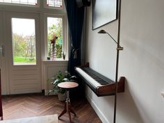 a living room with a piano in the corner next to a window and a chair