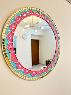 a colorful mirror hanging on the side of a wall