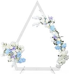 a white triangle with blue and white flowers in it on a stand against a white background