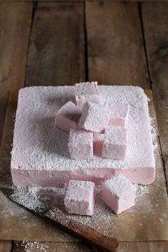 some sugar cubes on a cutting board with a knife