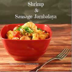 shrimp and sausage jambalya in a red bowl with a fork next to it