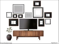 a flat screen tv sitting on top of a wooden entertainment center next to framed pictures