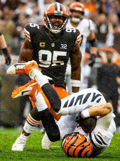 a football player is being tackled by an opposing team member on the field during a game