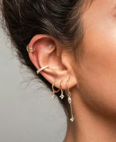 a close up of a person wearing ear rings and piercings on their ears,