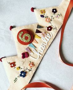 an ornament made out of felt with flowers on it and the word welcome