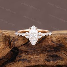 an oval cut diamond engagement ring on top of a piece of drift wood with the words,