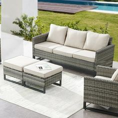 an outdoor living room with wicker furniture and a pool in the backgroud