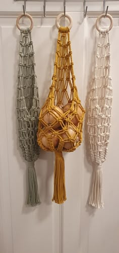 three macrame hanging from hooks on a door