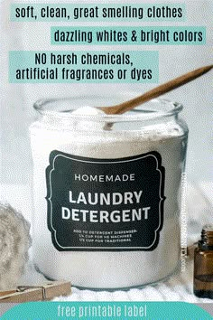 a jar filled with laundry detergent next to a wooden spoon