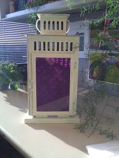 a decorative lantern sitting on top of a table next to some plants and other items