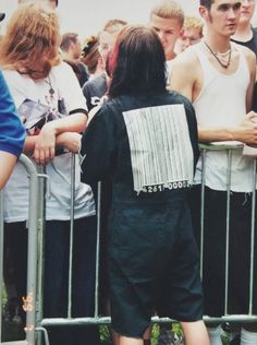 a man standing in front of a crowd of people behind a metal barricade