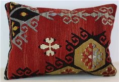 a red and black decorative pillow sitting on top of a white table