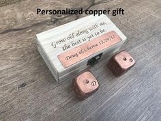 two wooden dices sitting on top of a table next to a box that says, personalized copper gift