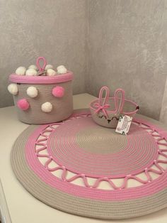 two baskets with pom - poms on top of a white table next to each other